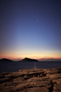 when the night coming just the lighthouse and the stars brighten the darkness